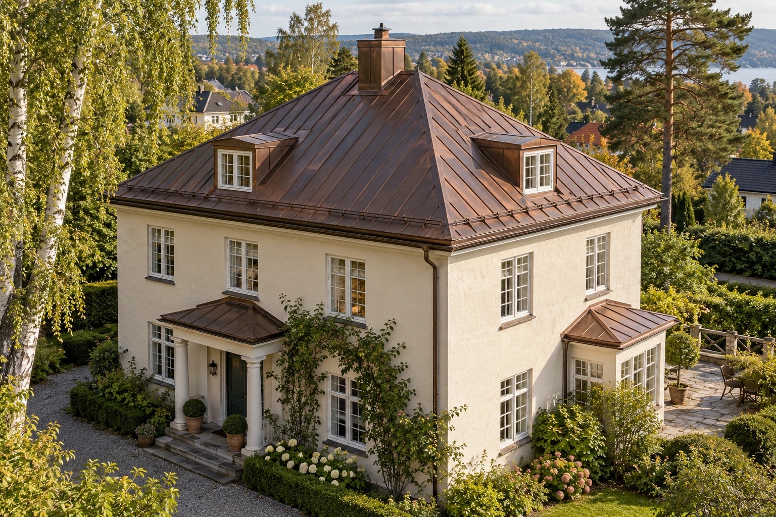 Lys pusset villa med brunpatinert kobbertak og tilpassede kobberrenner.